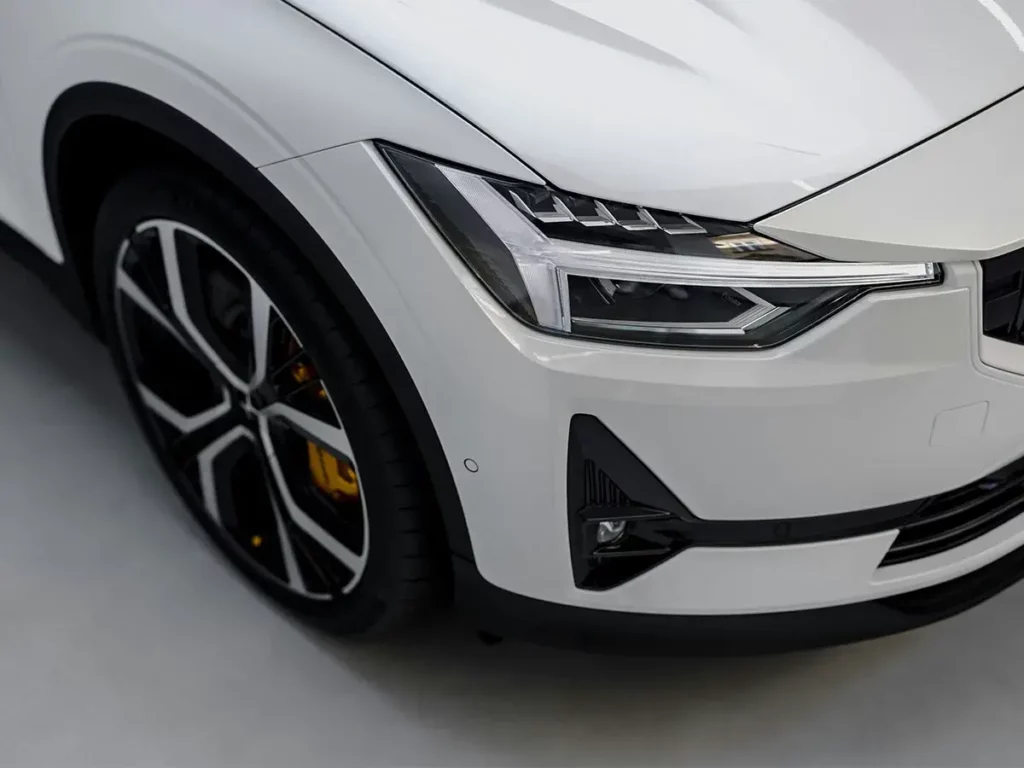 Faro delantero y diseño aerodinámico de un automóvil blanco moderno.