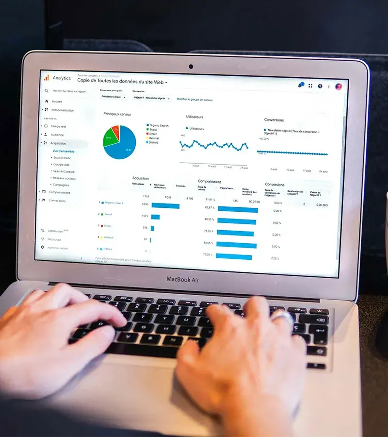 Laptop mostrando tableros de control y gráficas de analítica web para agencias.